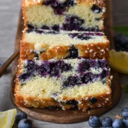 Sliced blueberry lemon mascarpone cake with visible berries and golden crumb