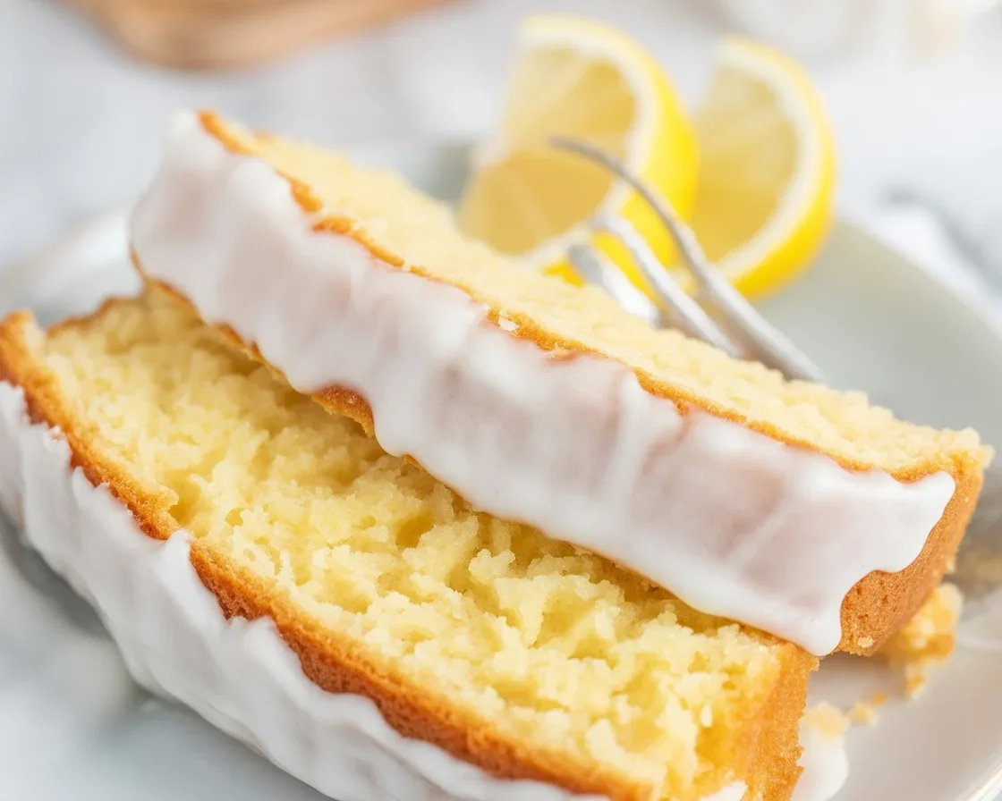Moist lemon cake topped with a tangy glaze and fresh lemon slices.