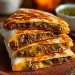 Cheeseburger quesadillas served with toppings and sauces on a plate
