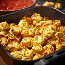 Crispy air fryer tortellini served in a bowl with dipping sauce