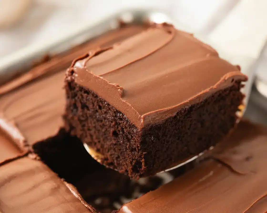 Slice of Vintage Mayonnaise Cake topped with chocolate frosting on a plate.