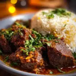 Delicious Indian Beef Curry served with rice and garnished with cilantro.