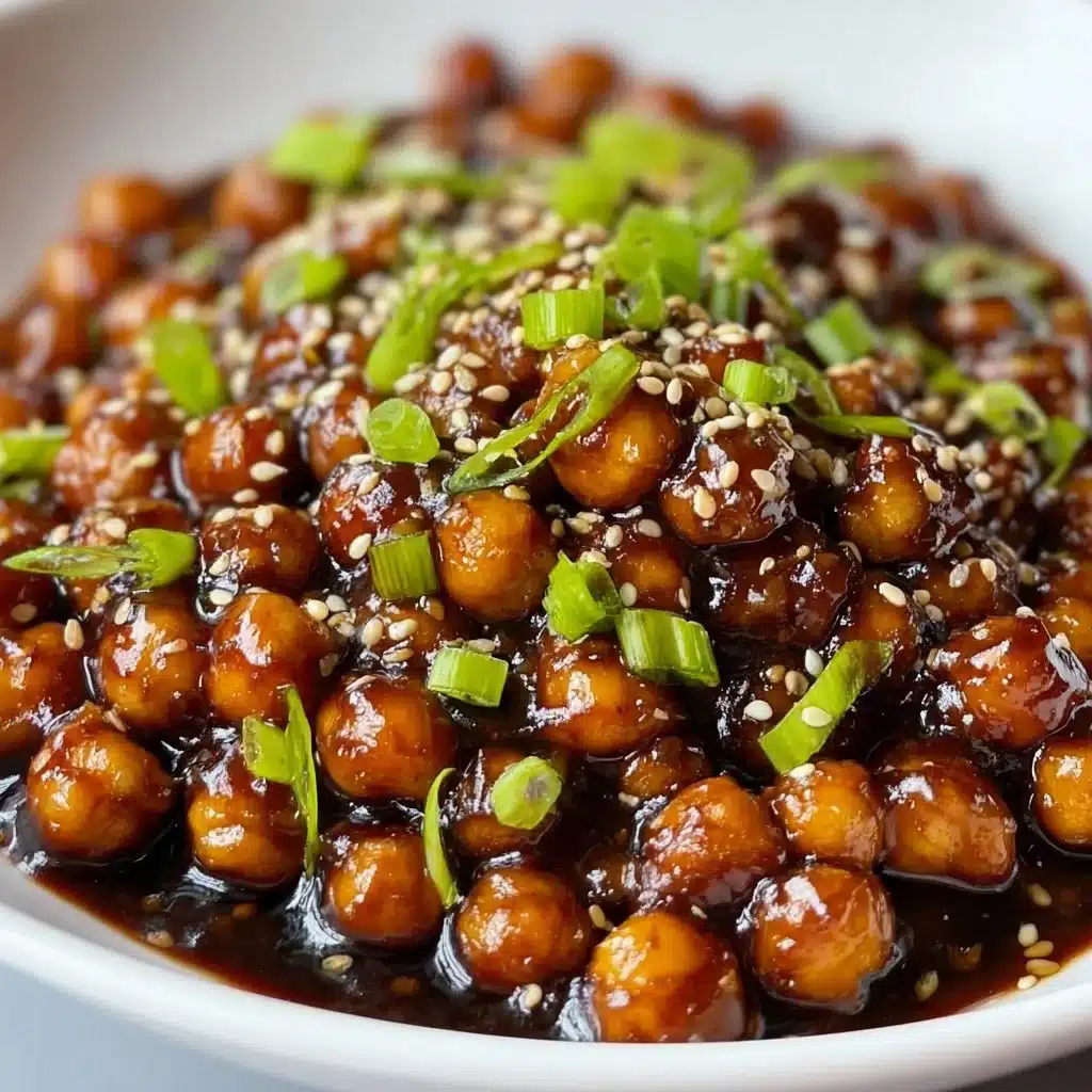 Delicious vegan sticky sesame chickpeas on a plate garnished with sesame seeds and green onions