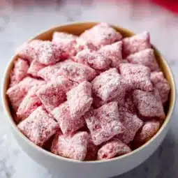 Strawberry Shortcake Puppy Chow dessert bowl filled with colorful treats