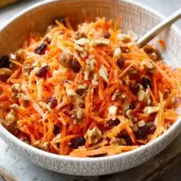 Bowl of easy creamy carrot raisin salad with fresh ingredients