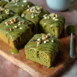 Slice of easy vegan matcha cake with green tea frosting on a plate.