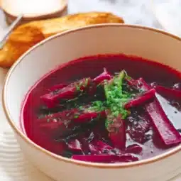 A bowl of vibrant Polish borscht soup made with beets and vegetables.