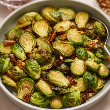 Crispy Air Fryer Maple Pecan Brussels Sprouts with garnished pecans and maple glaze.